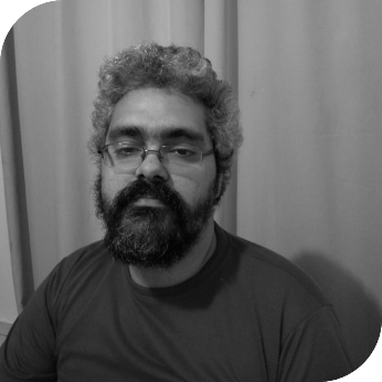 Foto em preto e branco de Rodrigo Silva do Ó, à esquerda da bio. Ele tem pele clara, cabelos grisalhos encaracolados, usa barba comprida e óculos de aros finos. Ele olha para a foto e não sorri, e usa uma camiseta azul.